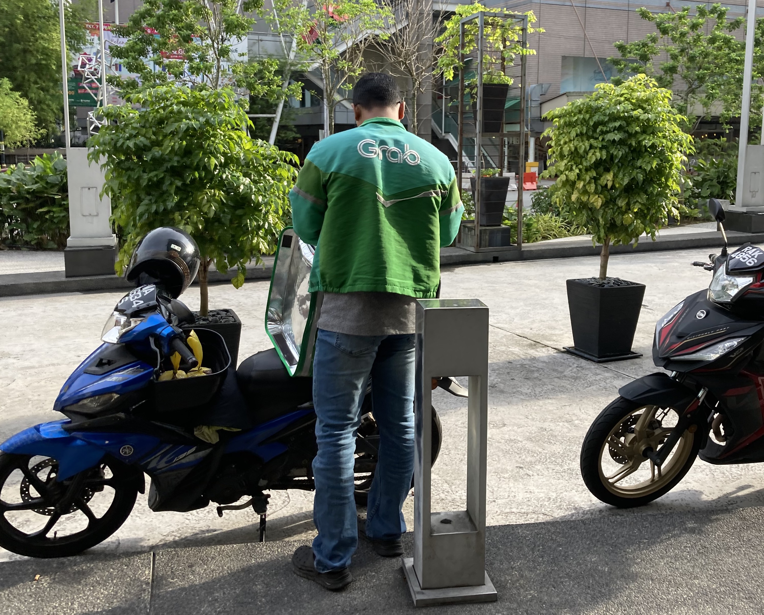 A Grab rider in Kuala Lumpur completes an order on the morning of the 2023 May Day march