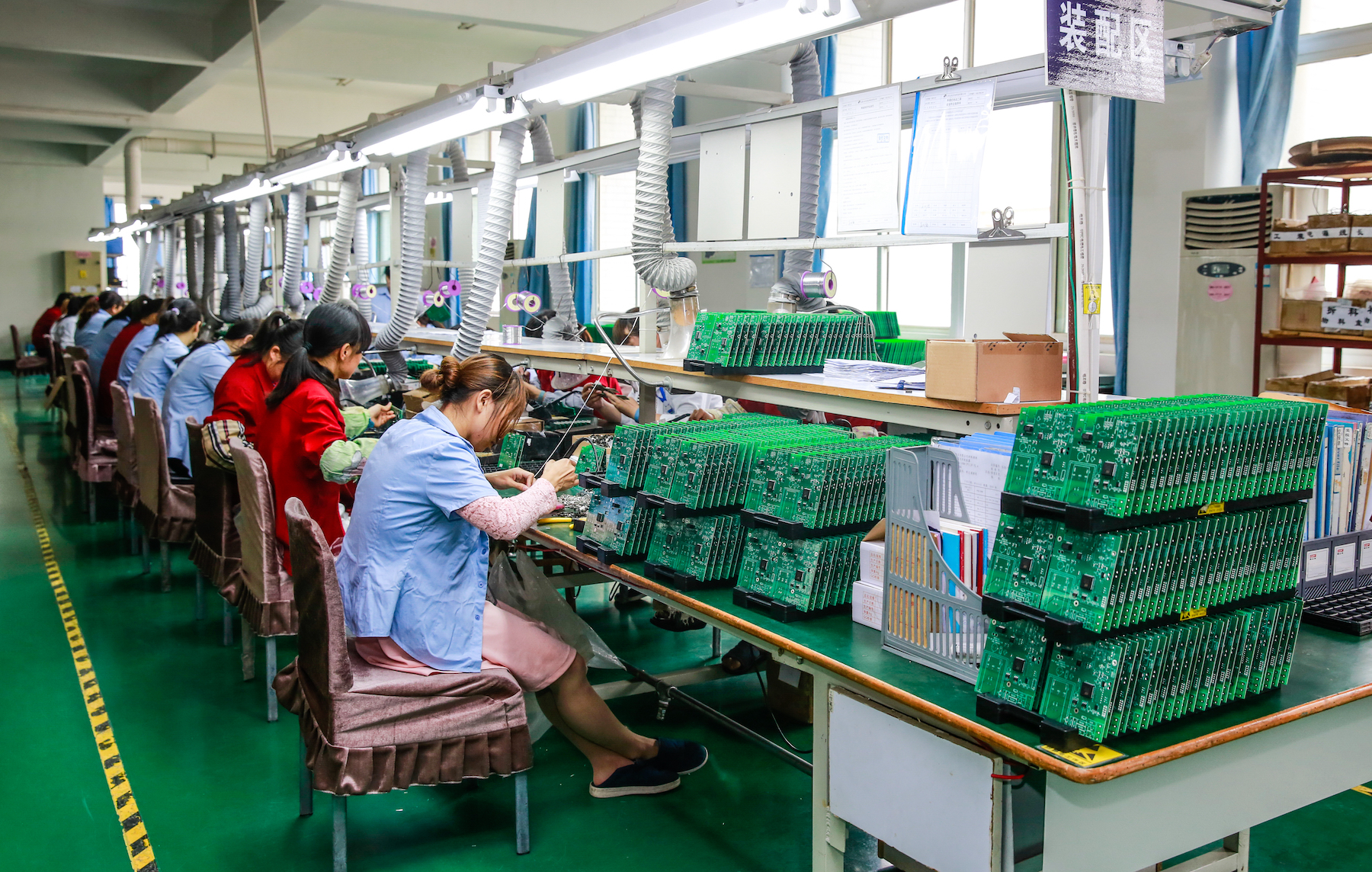 Workers in an electronics factory assemble circuit boards